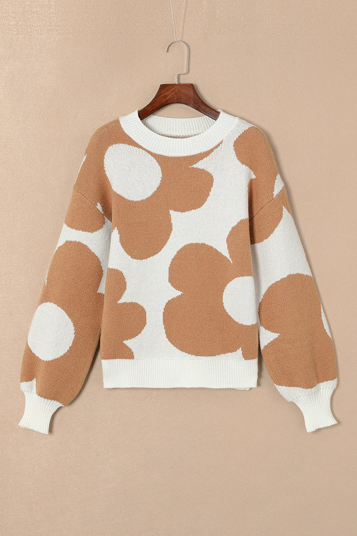 Brown and white patterned sweater on a hanger against a beige background